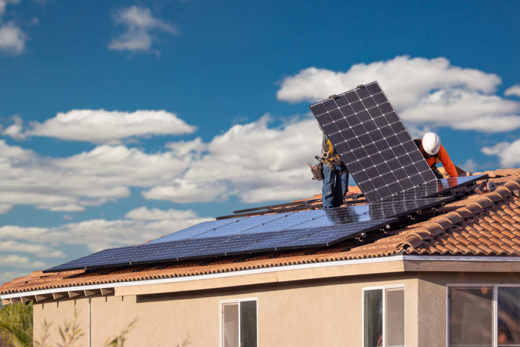 tecnicos instalando placas solares en un tejado indicando como mejorar la eficiencia energetica de una vivienda