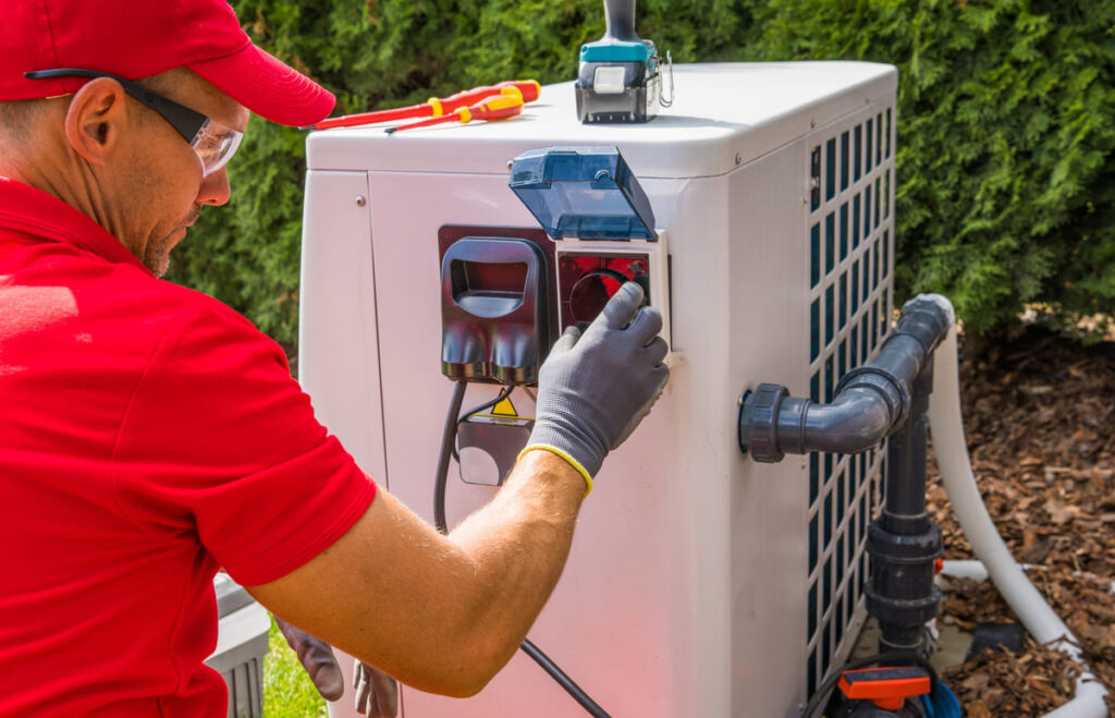 técnico revisando la instalacion bomba de calor con aerotermia en un jardin